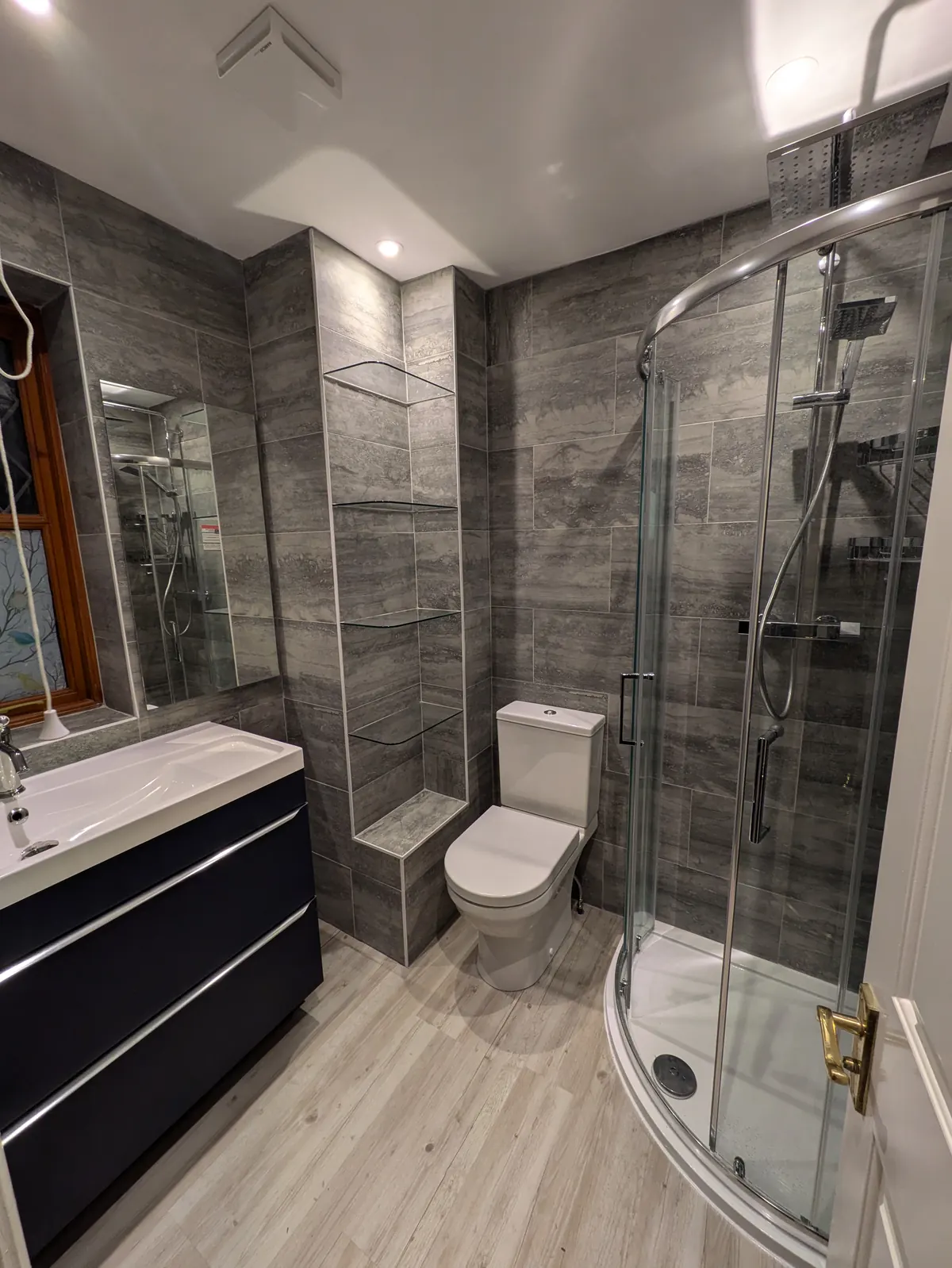 A bright bathroom with a white freestanding bath and exposed traditional taps